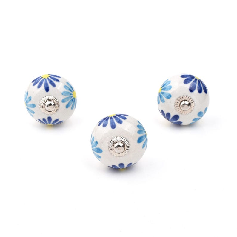 Assorted hand-painted ceramic knobs with blue and turquoise floral motifs for kitchen décor and knob cupboards.