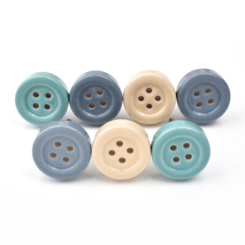 Hand-painted ceramic button knobs in cream, blue, turquoise; bold color cabinet hardware to match nursery decor.