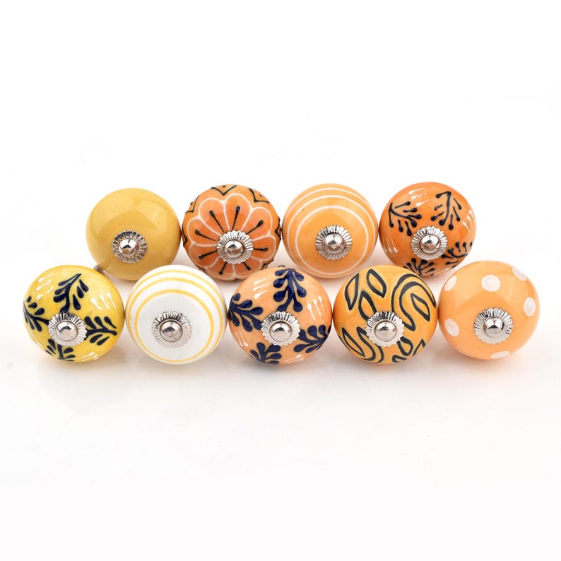 Hand-painted ceramic round knobs in yellow and orange with floral; dresser knobs and cabinet pulls for furniture hardware.