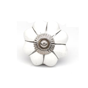 May include: White ceramic cabinet knob with a silver flower design and a silver knob in the centre.