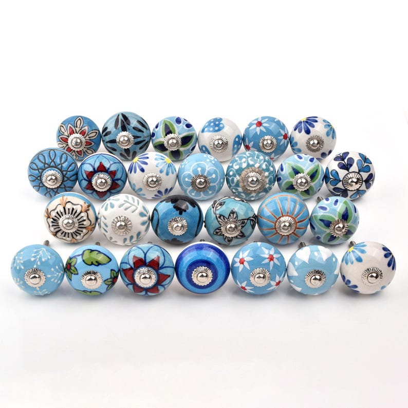 Assorted hand-painted ceramic knobs with blue and turquoise floral motifs for kitchen décor and knob cupboards.