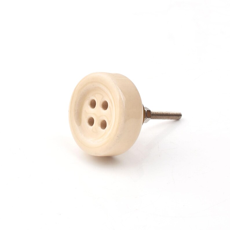 Hand-painted ceramic button knobs in cream, blue, turquoise; bold color cabinet hardware to match nursery decor.