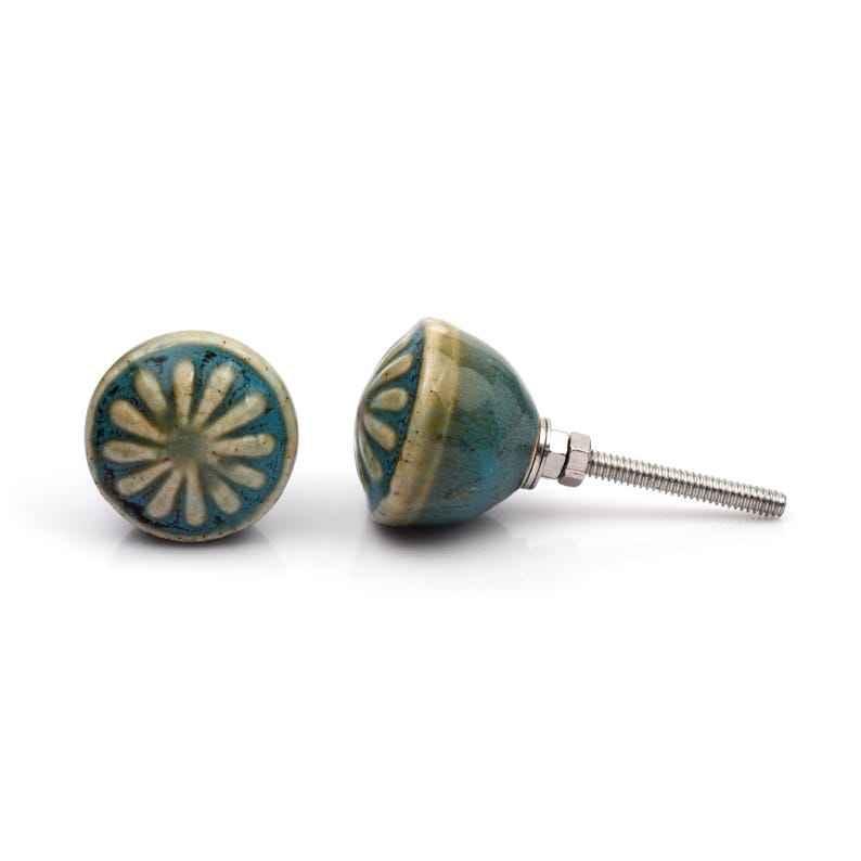 May include: A collection of twelve decorative cabinet knobs in various colours and patterns. Each knob features a round or oval shape with a metal bolt extending from the back. The designs include floral, geometric, and solid textures in shades of green, blue, orange, purple, white, and grey.
