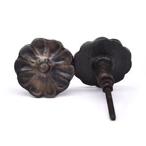 May include: Two black cast iron drawer pulls with a floral design. The pulls have a screw on the back for attaching to a drawer.