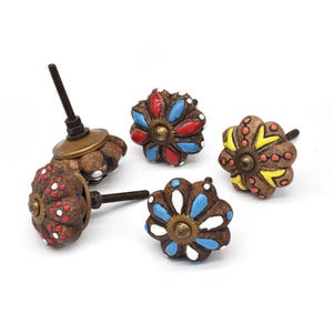 Hand-painted ceramic pumpkin knobs with colorful floral mandala designs in blue, white, red and yellow for cabinets.