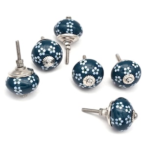 Könnte beinhalten: Sechs türknöpfe aus blaugrüner Keramik mit weißen Blumenmustern und silbernen Akzenten. Jeder Knopf hat eine Schraube zur Montage.