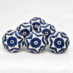 Könnte beinhalten: Sechs blaue und weiße Keramik-Knöpfe mit floralem Muster. Die Knöpfe sind rund und haben einen erhöhten Rand. Sie sind perfekt, um jedem Raum einen Hauch von Stil zu verleihen.