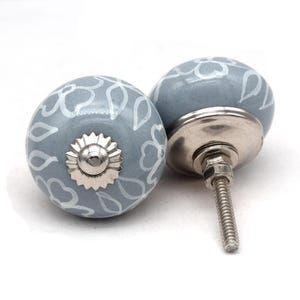 Grey ceramic knob with white hand-painted floral pattern; vintage shabby chic cabinet drawer pull with silver mounting stud.