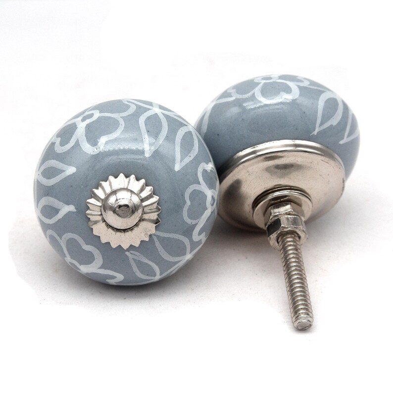 Grey ceramic knob with white hand-painted floral pattern; vintage shabby chic cabinet drawer pull with silver mounting stud.