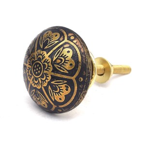 Etched brass flower cabinet knob with ornate gold pattern on dark background; decorative cabinet knobs for dresser hardware.