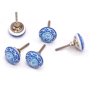 Peut inclure: Cinq boutons de meuble en céramique avec un motif floral bleu et blanc. Les boutons ont une forme ronde avec une vis métallique pour l'installation. Les boutons sont un élément de quincaillerie décoratif pour les meubles.