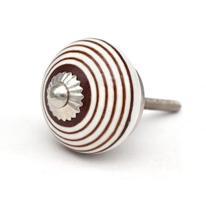 May include: White ceramic knob with brown stripes and a silver metal top. The knob has a screw on the back.