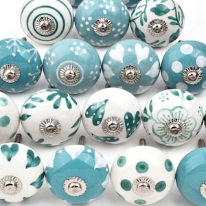 May include: Assortment of 15 ceramic cabinet knobs with various blue and white patterns. The knobs have a silver metal base.