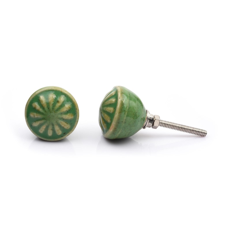 May include: A collection of twelve decorative cabinet knobs in various colours and patterns. Each knob features a round or oval shape with a metal bolt extending from the back. The designs include floral, geometric, and solid textures in shades of green, blue, orange, purple, white, and grey.