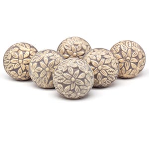 Könnte beinhalten: Sechs Keramik-Knöpfe mit einem floralen Design in Beige- und Grautönen.
