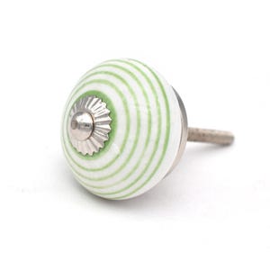 May include: White ceramic knob with a green and white striped pattern. The knob has a silver metal base.