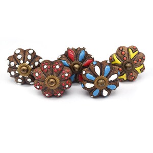 Hand-painted ceramic pumpkin knobs with colorful floral mandala designs in blue, white, red and yellow for cabinets.