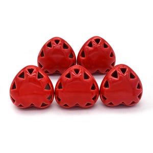 Peut inclure: Cinq poignées de tiroir en forme de cœur en céramique rouge avec un motif découpé décoratif.