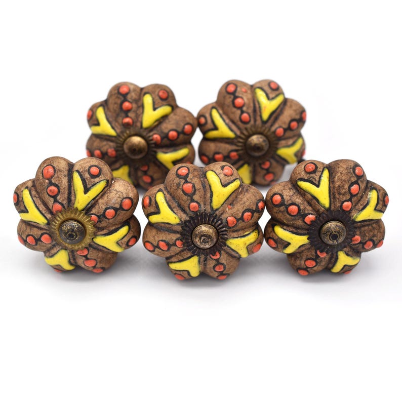 Hand-painted ceramic pumpkin knobs with colorful floral mandala designs in blue, white, red and yellow for cabinets.