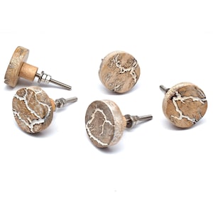 May include: Five round wooden knobs with a white crackle design. The knobs have a silver screw and are perfect for adding a rustic touch to furniture.