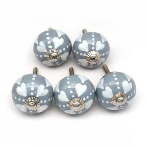 gray ceramic cabinet knobs, hand-painted in white with stripes, dots, flowers, stars, and hearts.