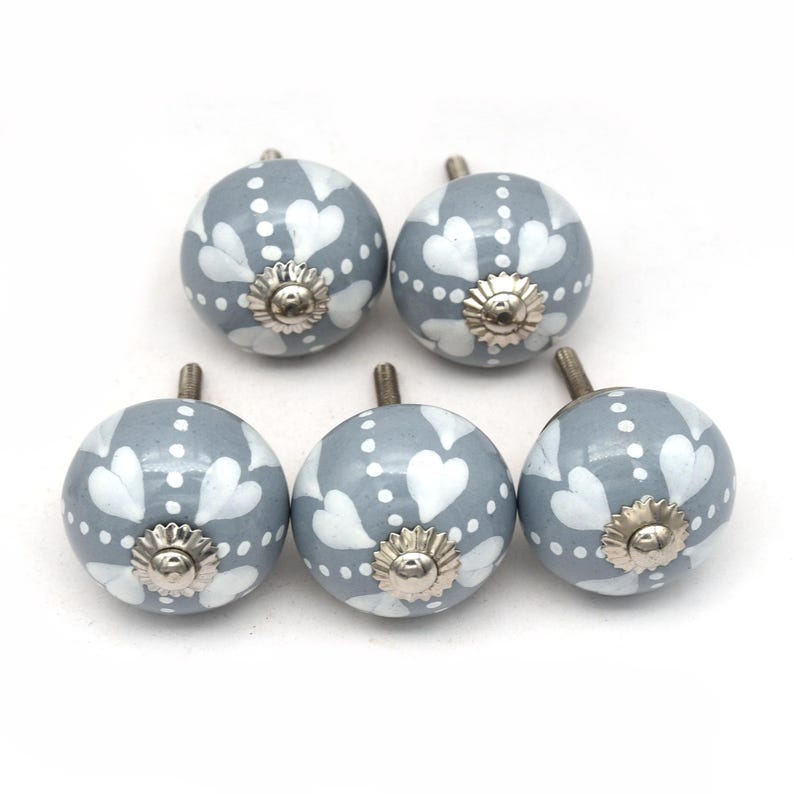 gray ceramic cabinet knobs, hand-painted in white with stripes, dots, flowers, stars, and hearts.