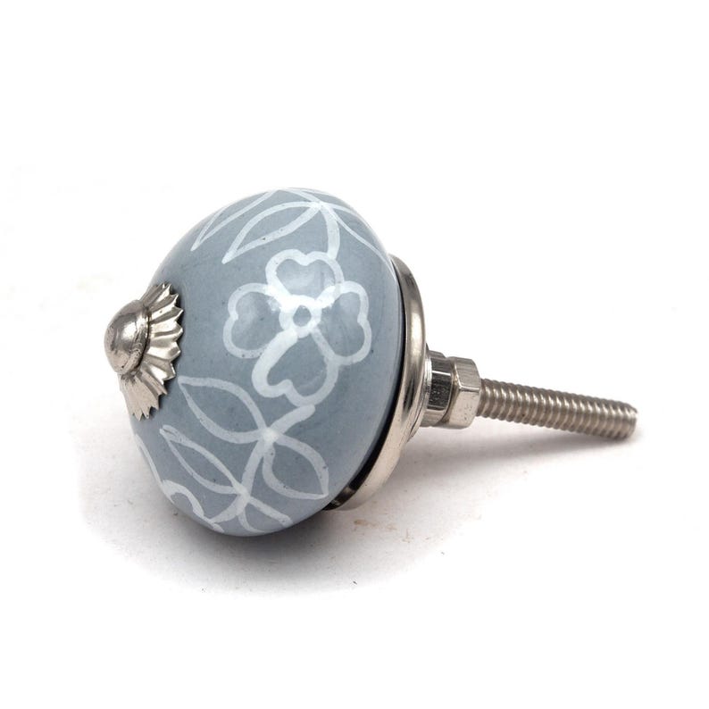 Grey ceramic knob with white hand-painted floral pattern; vintage shabby chic cabinet drawer pull with silver mounting stud.