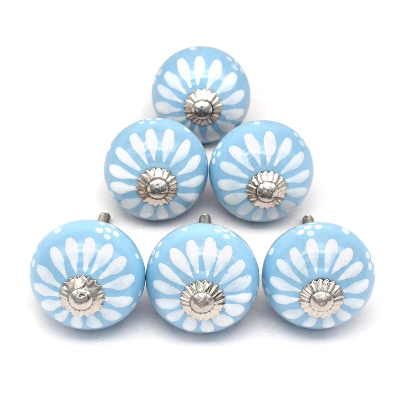 Six sky-blue ceramic cabinet knobs with white daisy patterns and silver centers, perfect as drawer knobs for cabinets.