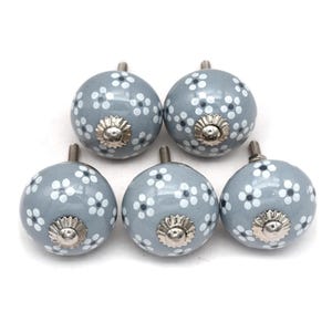 gray ceramic cabinet knobs, hand-painted in white with stripes, dots, flowers, stars, and hearts.