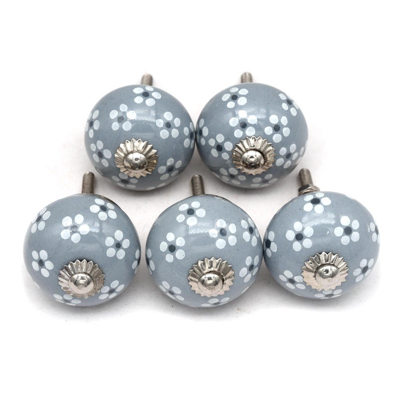 gray ceramic cabinet knobs, hand-painted in white with stripes, dots, flowers, stars, and hearts.