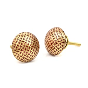 May include: Two decorative cabinet knobs with a woven pattern in gold and red. The knobs have a round shape and a threaded post for easy installation. These knobs are perfect for adding a touch of elegance to any furniture piece.