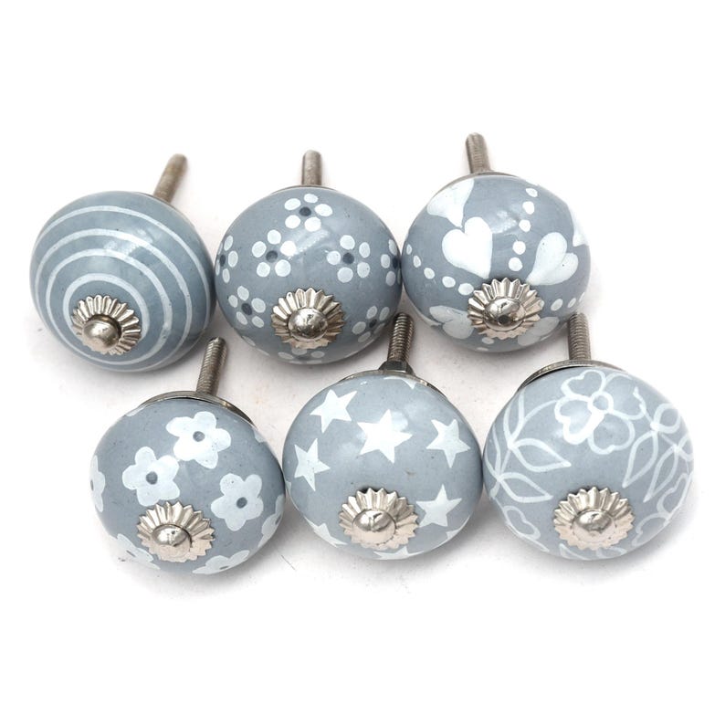 gray ceramic cabinet knobs, hand-painted in white with stripes, dots, flowers, stars, and hearts.