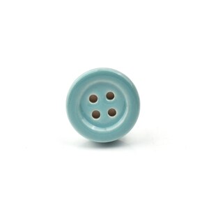 Hand-painted ceramic button knobs in cream, blue, turquoise; bold color cabinet hardware to match nursery decor.