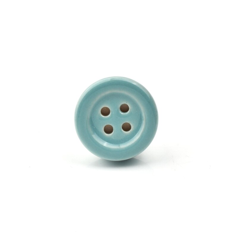 Hand-painted ceramic button knobs in cream, blue, turquoise; bold color cabinet hardware to match nursery decor.