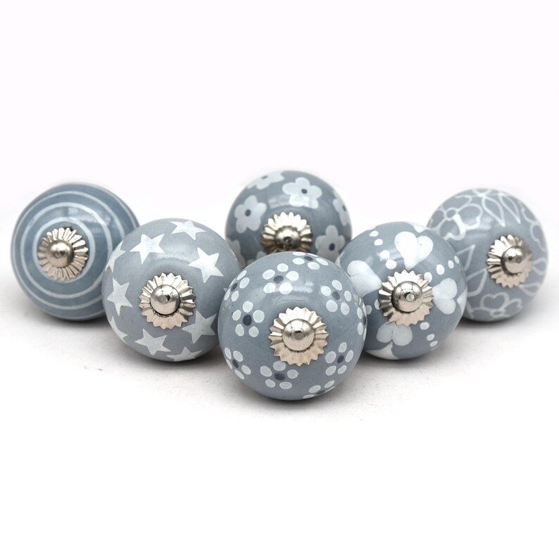 gray ceramic cabinet knobs, hand-painted in white with stripes, dots, flowers, stars, and hearts.