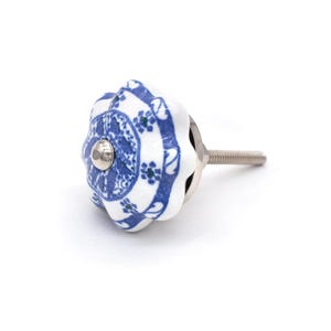 Peut inclure: Bouton de meuble en céramique blanche et bleue avec un motif floral. Le bouton a une vis en métal argenté et un centre en métal argenté. Le bouton mesure environ 3,8 cm de diamètre.