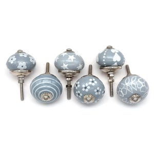 gray ceramic cabinet knobs, hand-painted in white with stripes, dots, flowers, stars, and hearts.