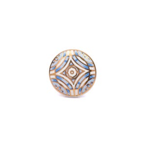 May include: A round ceramic knob featuring a symmetrical geometric pattern in shades of light blue, white, and gold. The design consists of curved lines and floral-like motifs radiating from a central circular element with a gold-toned border.