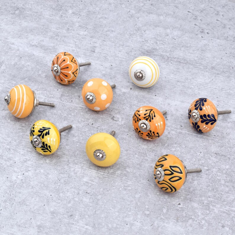 Hand-painted ceramic round knobs in yellow and orange with floral; dresser knobs and cabinet pulls for furniture hardware.