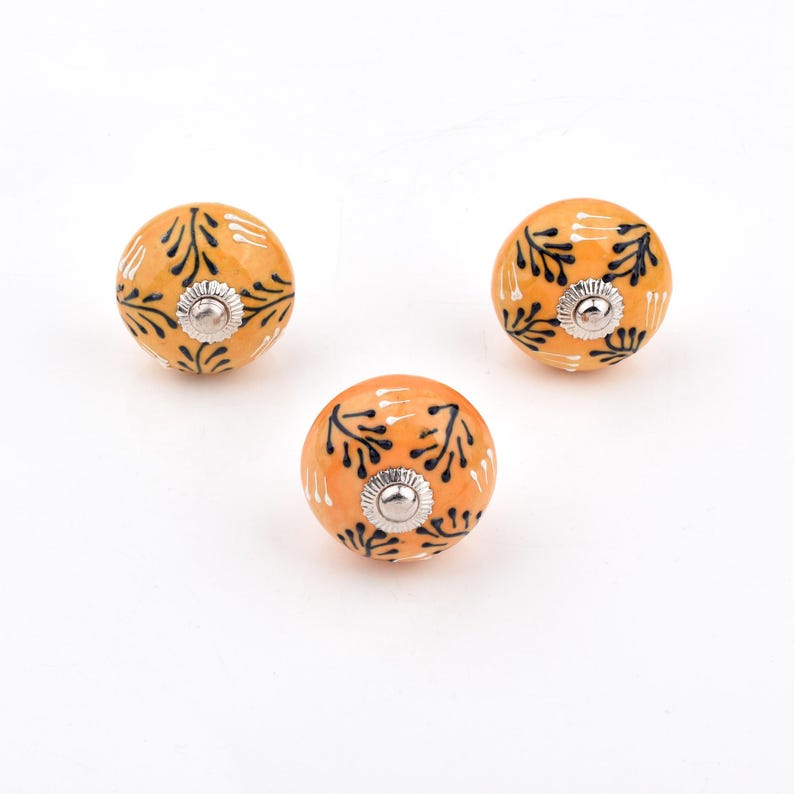 Hand-painted ceramic round knobs in yellow and orange with floral; dresser knobs and cabinet pulls for furniture hardware.