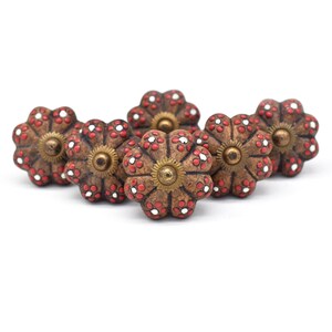 Hand-painted ceramic pumpkin knobs with colorful floral mandala designs in blue, white, red and yellow for cabinets.