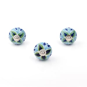 Assorted hand-painted ceramic knobs with blue and turquoise floral motifs for kitchen décor and knob cupboards.