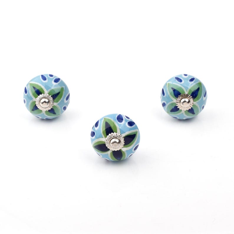 Assorted hand-painted ceramic knobs with blue and turquoise floral motifs for kitchen décor and knob cupboards.