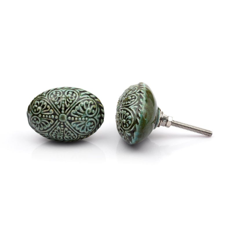 May include: A collection of twelve decorative cabinet knobs in various colours and patterns. Each knob features a round or oval shape with a metal bolt extending from the back. The designs include floral, geometric, and solid textures in shades of green, blue, orange, purple, white, and grey.