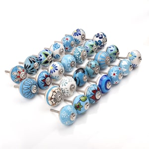 Assorted hand-painted ceramic knobs with blue and turquoise floral motifs for kitchen décor and knob cupboards.