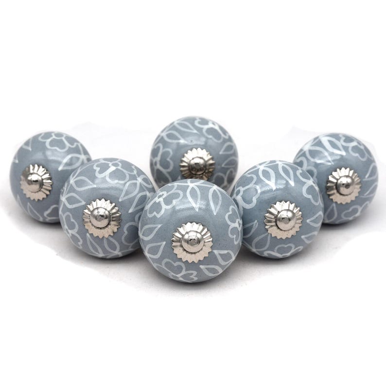 Grey ceramic knob with white hand-painted floral pattern; vintage shabby chic cabinet drawer pull with silver mounting stud.