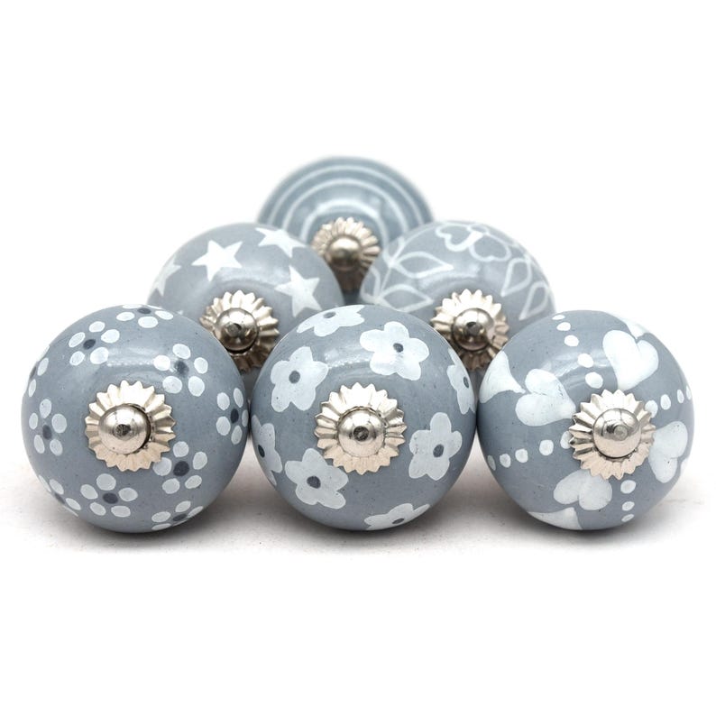 gray ceramic cabinet knobs, hand-painted in white with stripes, dots, flowers, stars, and hearts.
