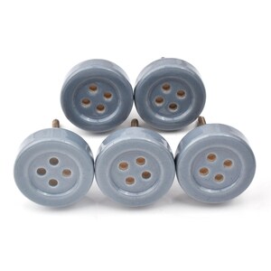 Hand-painted ceramic button knobs in cream, blue, turquoise; bold color cabinet hardware to match nursery decor.