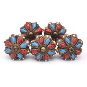 Hand-painted ceramic pumpkin knobs with colorful floral mandala designs in blue, white, red and yellow for cabinets.