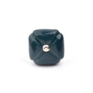 Può includere: Pomello quadrato, verde scuro, con centro argentato. Il pomello ha un design sfaccettato, che gli conferisce un aspetto strutturato. L'hardware è probabilmente per mobili come cassetti o armadi.